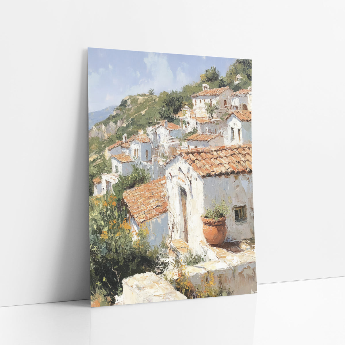 Terracotta Hillside Village Mediterranean art print leaning against a white wall – painting-style scene of white houses