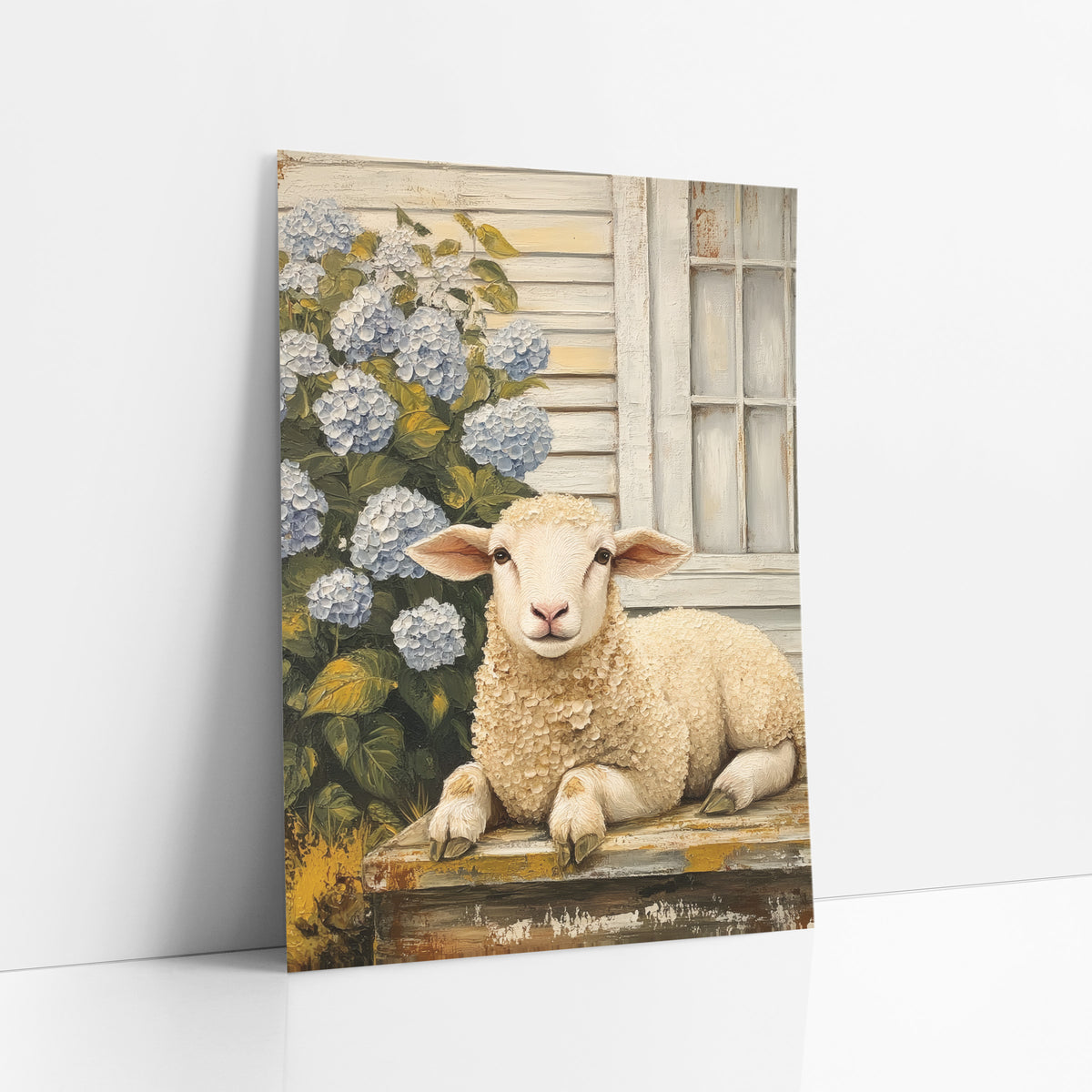 Lamb Beside Blue Hydrangeas Farmhouse art print leaning against a white wall – cream lamb resting on a worn wooden step