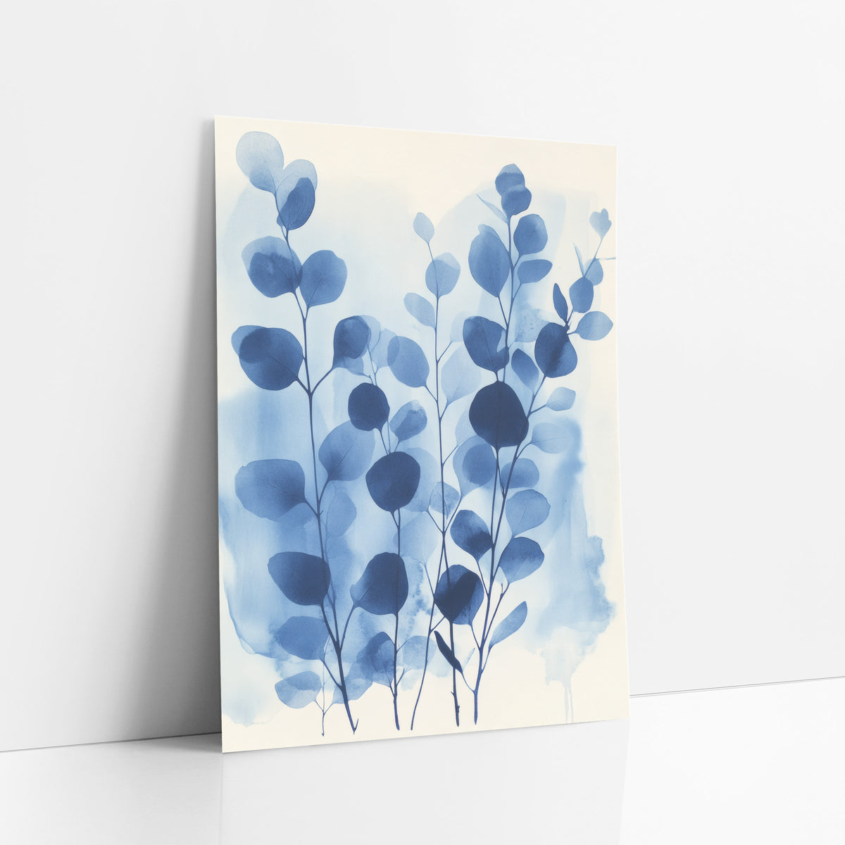 Tall Indigo Eucalyptus Washes art print leaning against a white wall – eucalyptus stems with round indigo and sky blue leaves