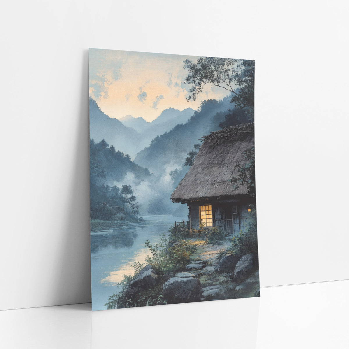 Misty River Thatched Cottage Japandi art print leaning against a white wall – thatched cottage with a glowing window