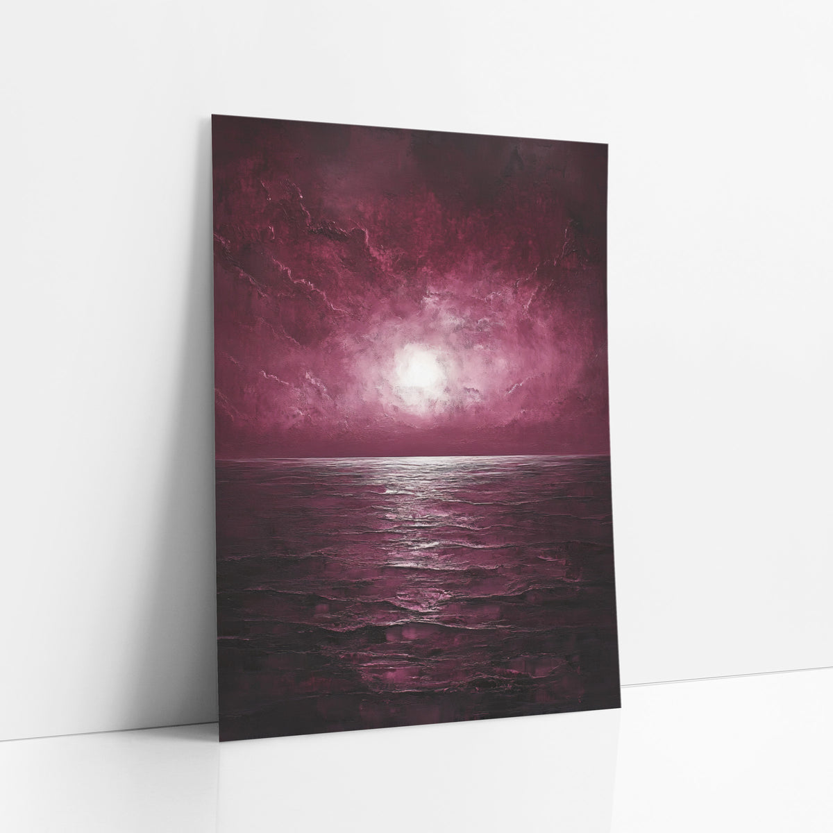 Glowing Dusk Seascape Moody Luxe art print leaning against a white wall – burgundy sky with a bright white glow above a dark