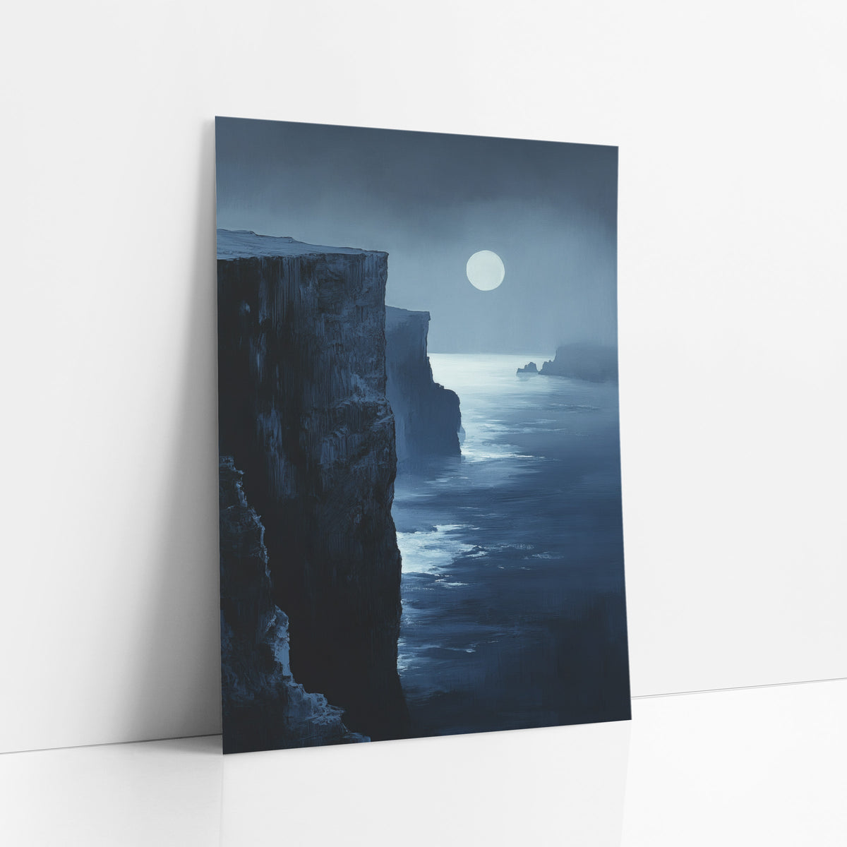 Midnight Blue Moonlit Cliffs Coastal art print leaning against a white wall – tall dark coastal cliffs beside a calm midnight