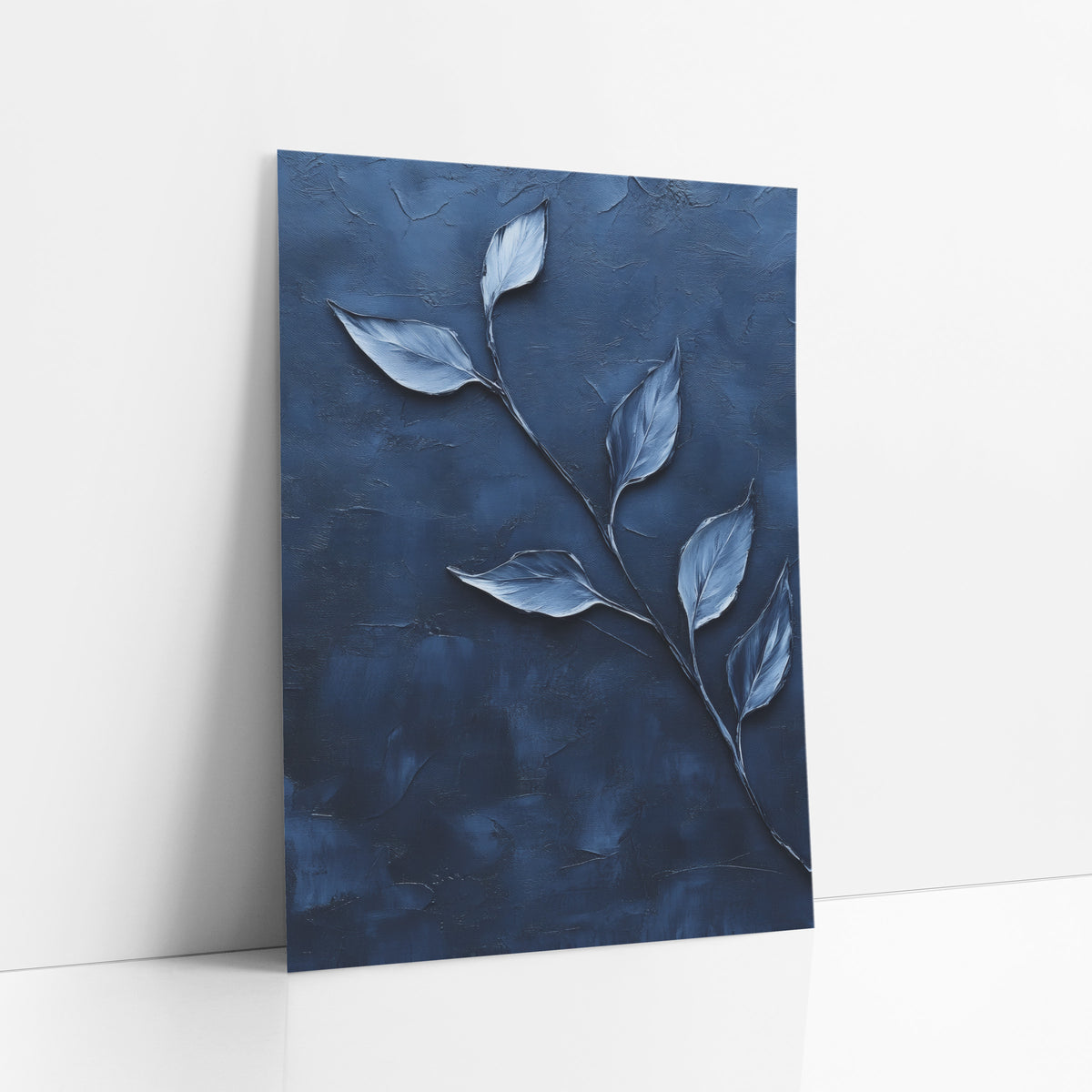 Navy Diagonal Leaf Sprig Contemporary art print leaning against a white wall – curving stem with six pale silver-blue leaves