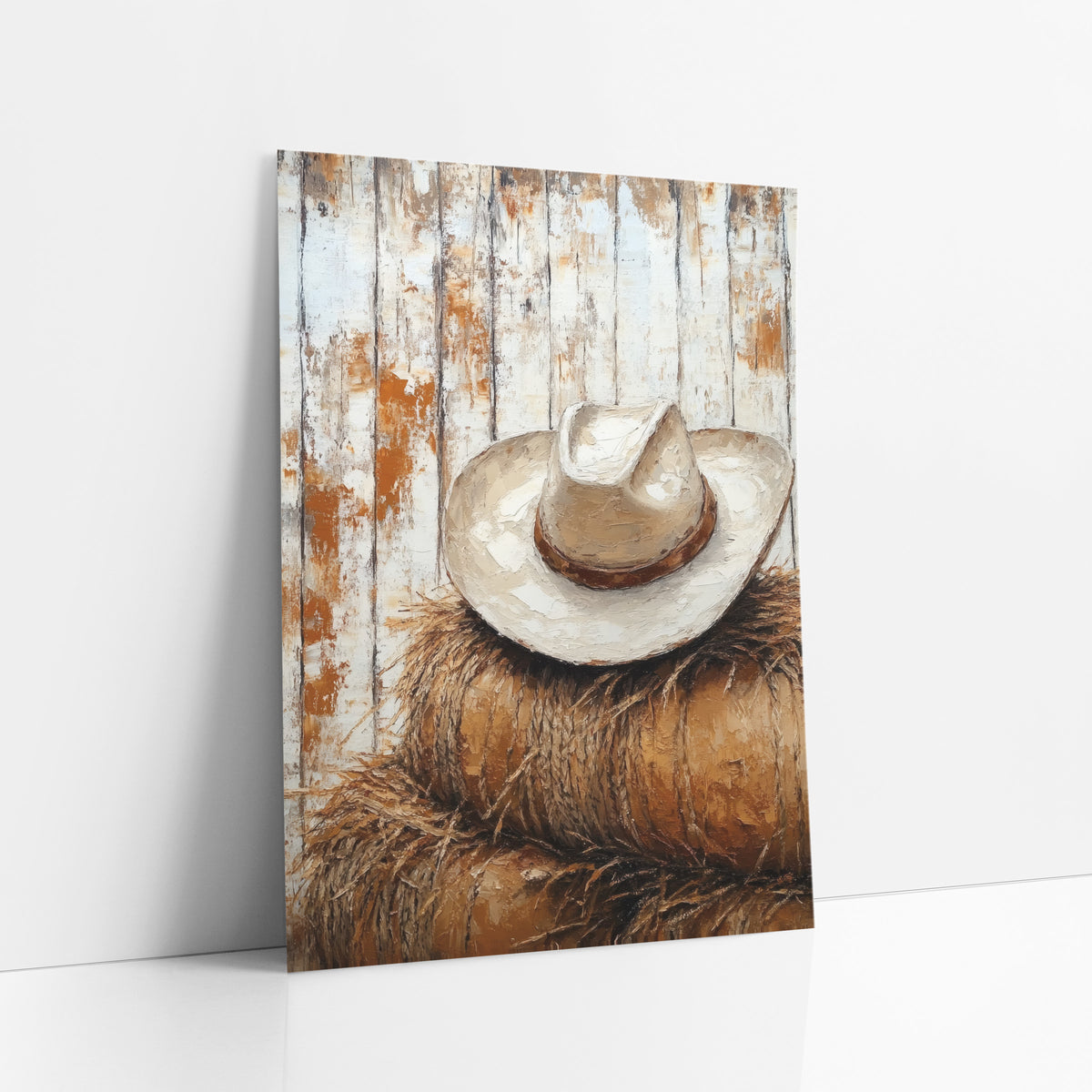 Cream Hat Round Bales Rustic art print leaning against a white wall – cream cowboy hat with brown band resting on stacked hay