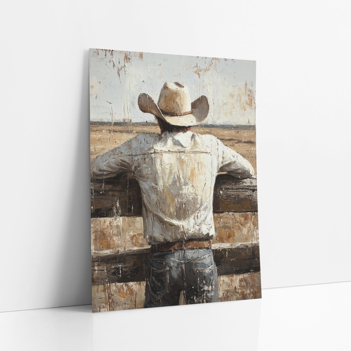 Cowboy Fence Prairie Western Rustic art print leaning against a white wall – cowboy in cream hat and white shirt seen