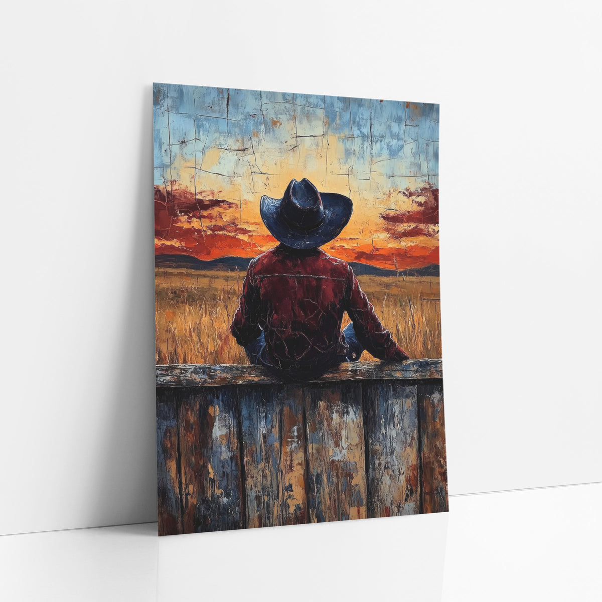 Cowboy Seated Wheatfield Glow Western art print leaning against a white wall – cowboy in dark hat and burgundy jacket seen