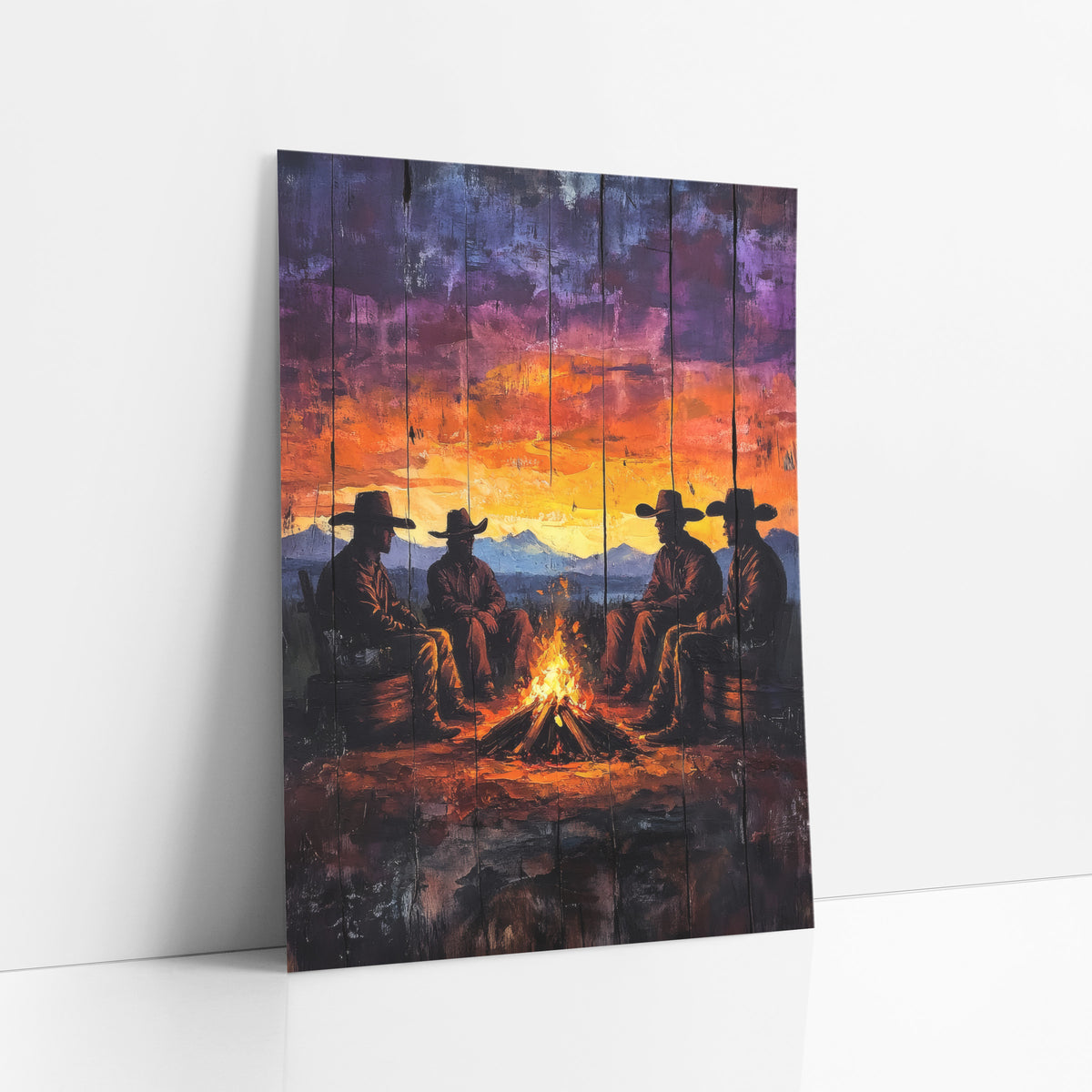 Cowboy Campfire Sunset Western Rustic art print leaning against a white wall – four cowboys in wide-brim hats sit around