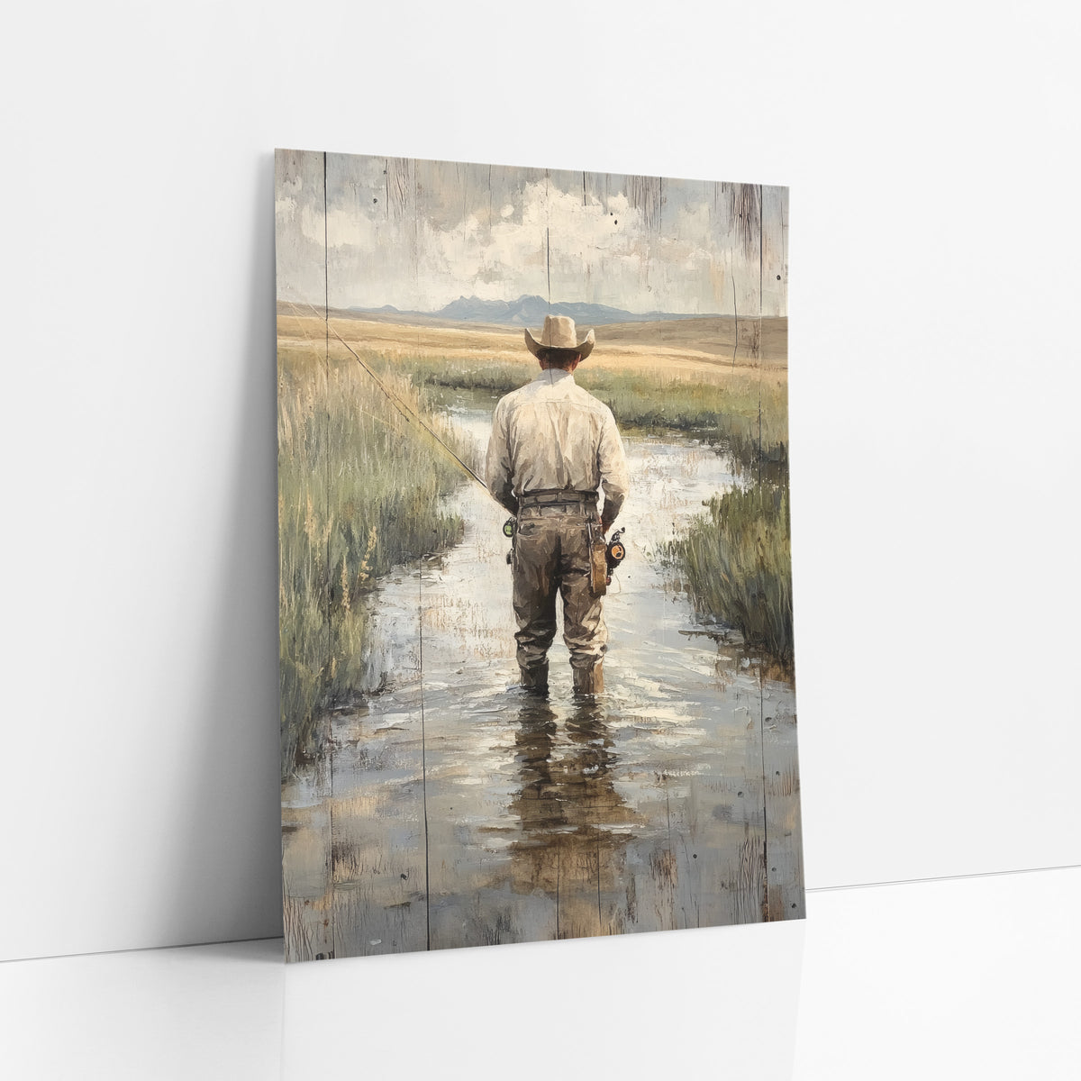 Prairie Stream Fly Fisherman Western art print leaning against a white wall – man in a wide-brimmed hat fly fishing