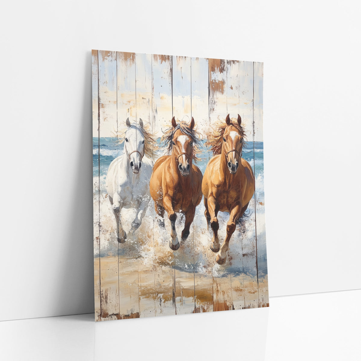 Three Galloping Beach Horses Whitewashed art print leaning against a white wall – three horses, one white and two chestnut