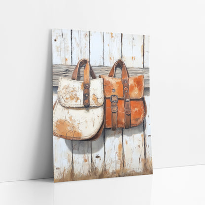Rustic Leather Saddlebags Western Farmhouse art print leaning against a white wall – two weathered leather saddlebags, one