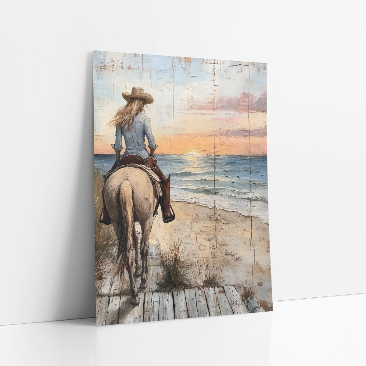 Cowgirl Rear View Boardwalk Dusk art print leaning against a white wall – cowgirl in tan hat riding a cream horse along