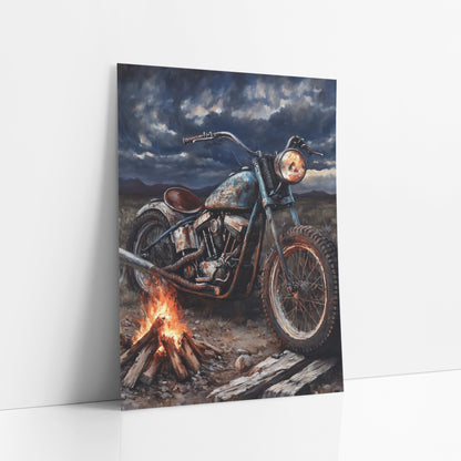 Rusty Chopper Campfire Storm art print leaning against a white wall – rusty vintage motorcycle parked beside a campfire