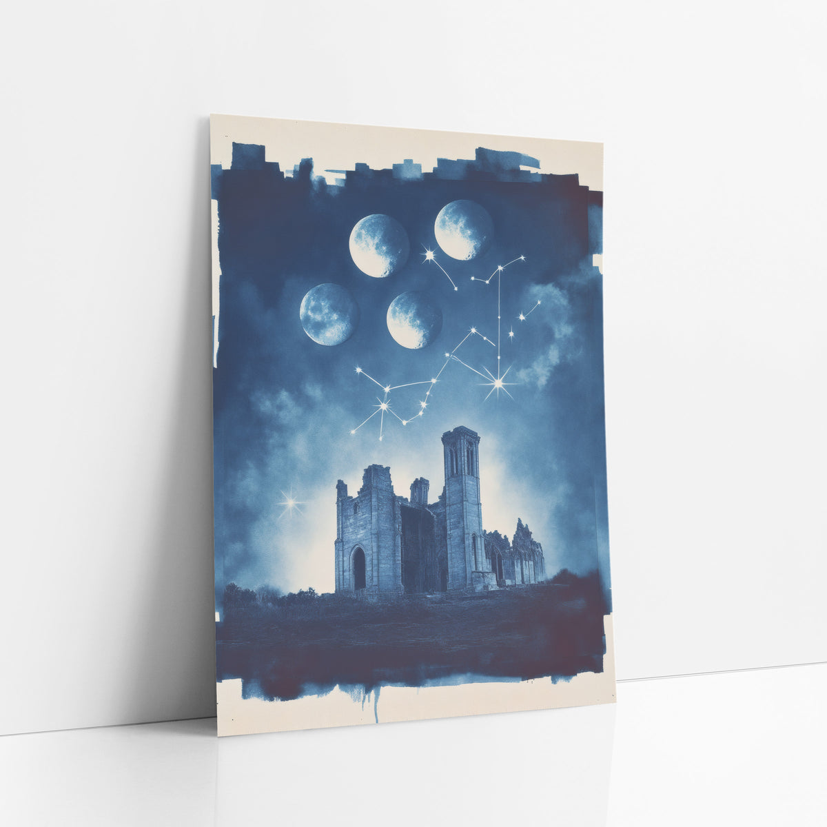 Moon Phases Over Ruins Celestial art print leaning against a white wall – navy blue night scene of four moon phases and star