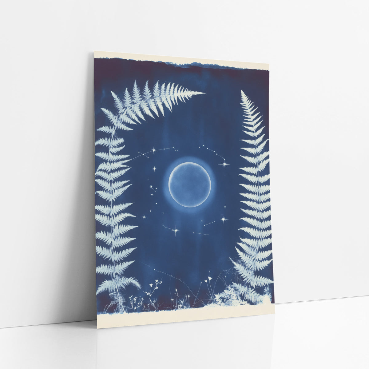 Midnight Blue Fern Moon Botanical art print leaning against a white wall – white fern fronds frame a glowing moon and small