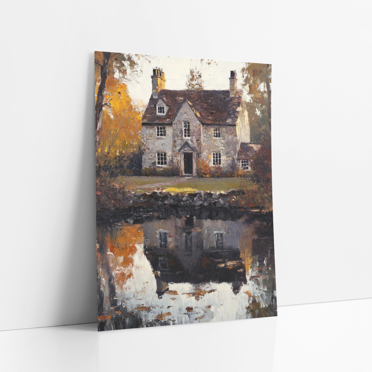 Golden Cottage Lawn Rustic Autumn art print leaning against a white wall – gray stone cottage with chimneys reflected