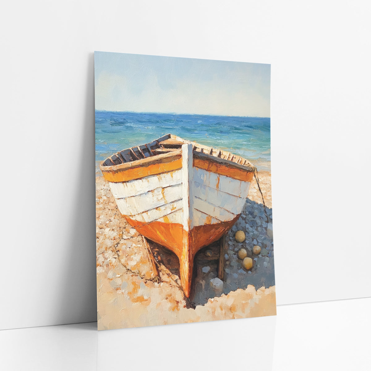 Orange White Rowboat Beach Coastal art print leaning against a white wall – white and orange wooden rowboat on a pebble beach