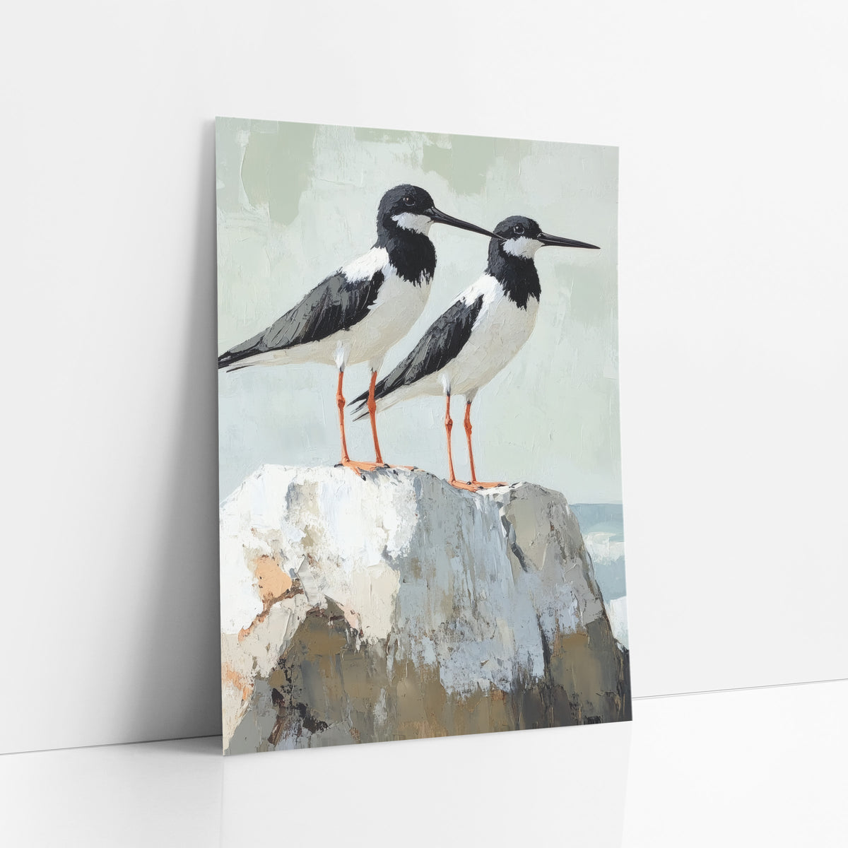 Black White Shorebird Pair Coastal art print leaning against a white wall – two black and white shorebirds with orange legs